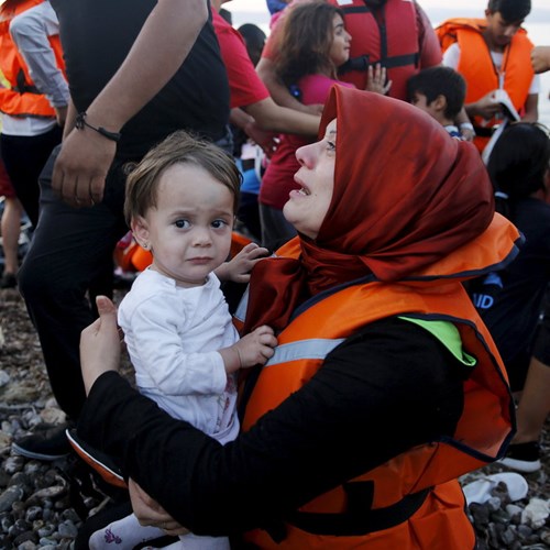 Em bé trong vòng tay một người phụ nữ cứu hộ